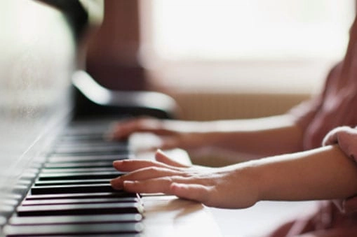 Picture of two hands playing keys on a piano