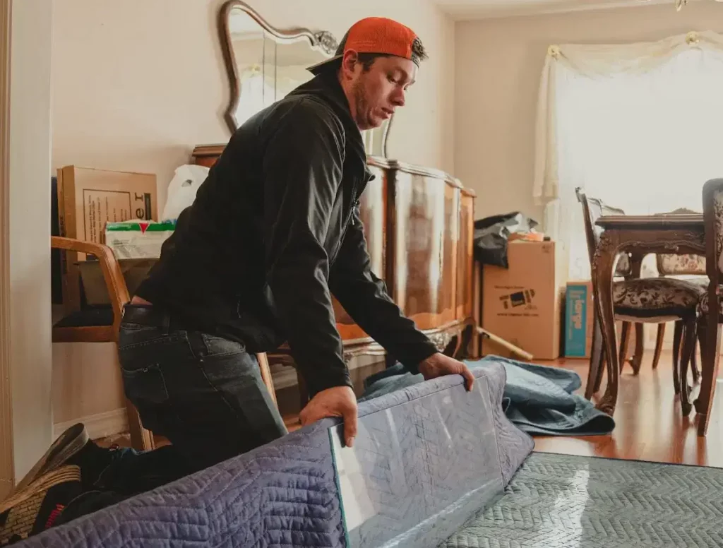 Heather Movers LLC team member wrapping furniture with packing blanket