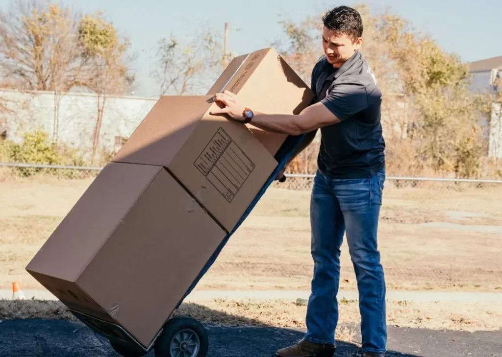 Heather Movers LLC team member using dolly for cardboard boxes